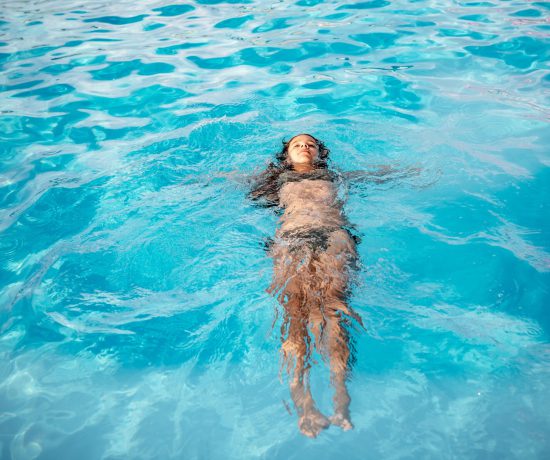 Happy teenager girl in a green swimsuit